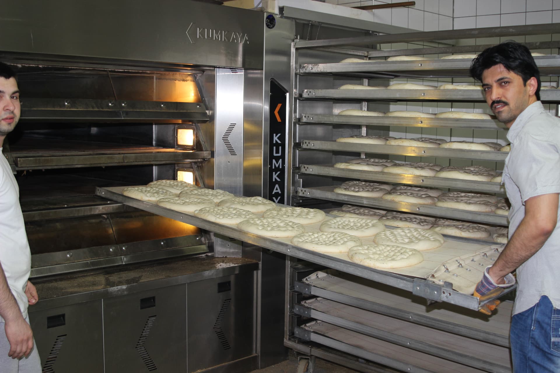 Bäcker der HAK Bäckerei beim Beladen des Ofens mit Fladenbrot-Teiglingen